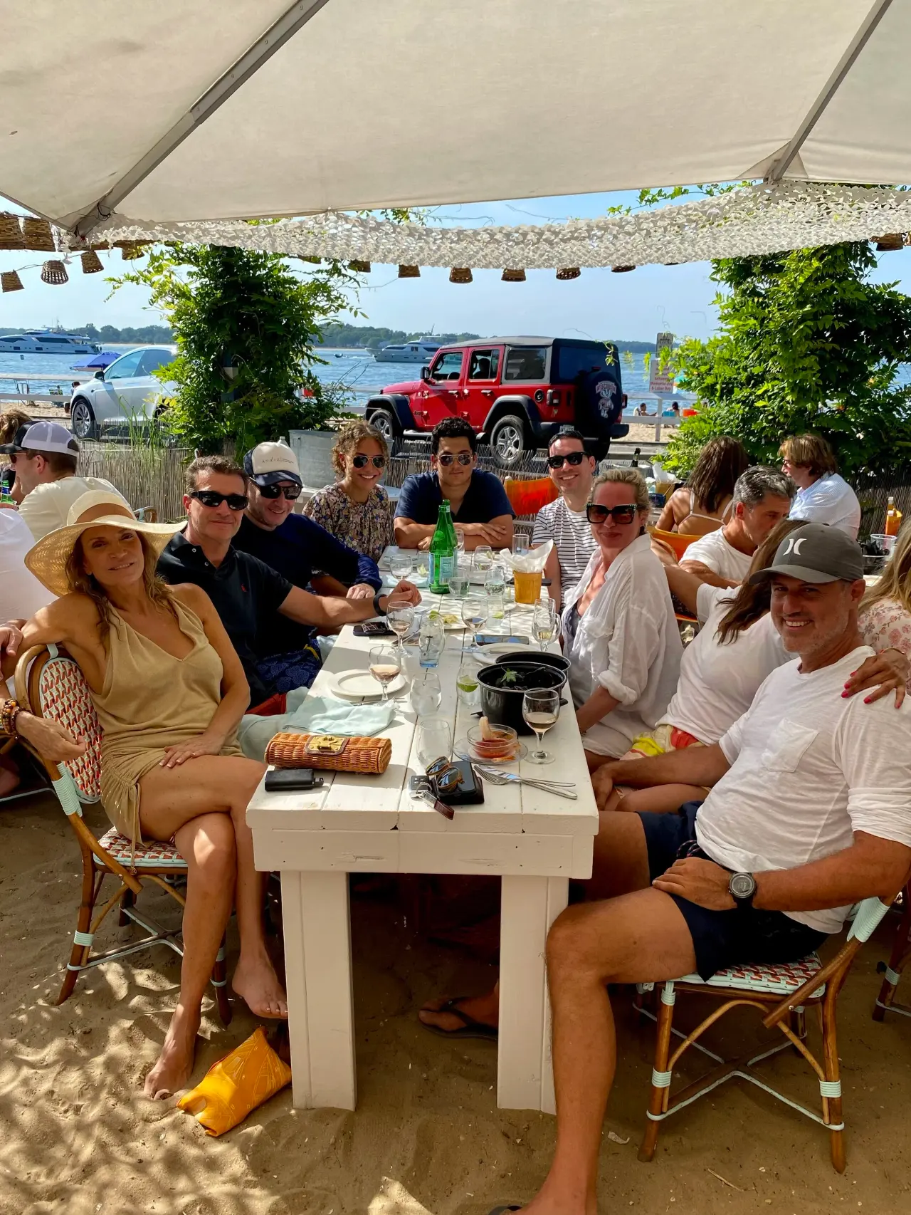 A long table of clients and friends by the water